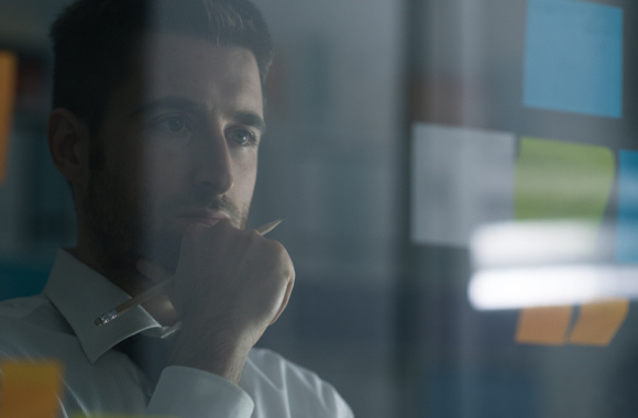 un hombre contemplando y mirando las notas adhesivas